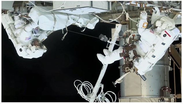NASA spacewalkers (from left) Nichole Ayers and Anne McClain work together at the International Space Station’s Port-4 truss structure to install a modification kit readying the orbital outpost for a future rollout solar array. Credit: NASA