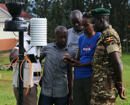 Catherine, wearing a NASA shirt, surrounded by officers doing field work