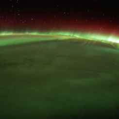 An image of the aurora australis as seen from the International Space Station. Green and red aurora are visible over the Earth.