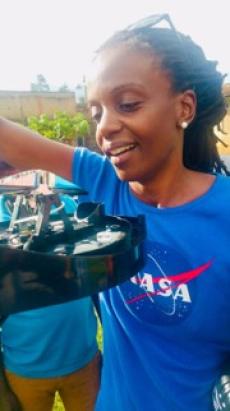 Catherine Nakalembe outdoors, wearing a NASA shirt