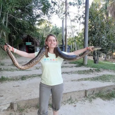 woman holding a snake outdoors